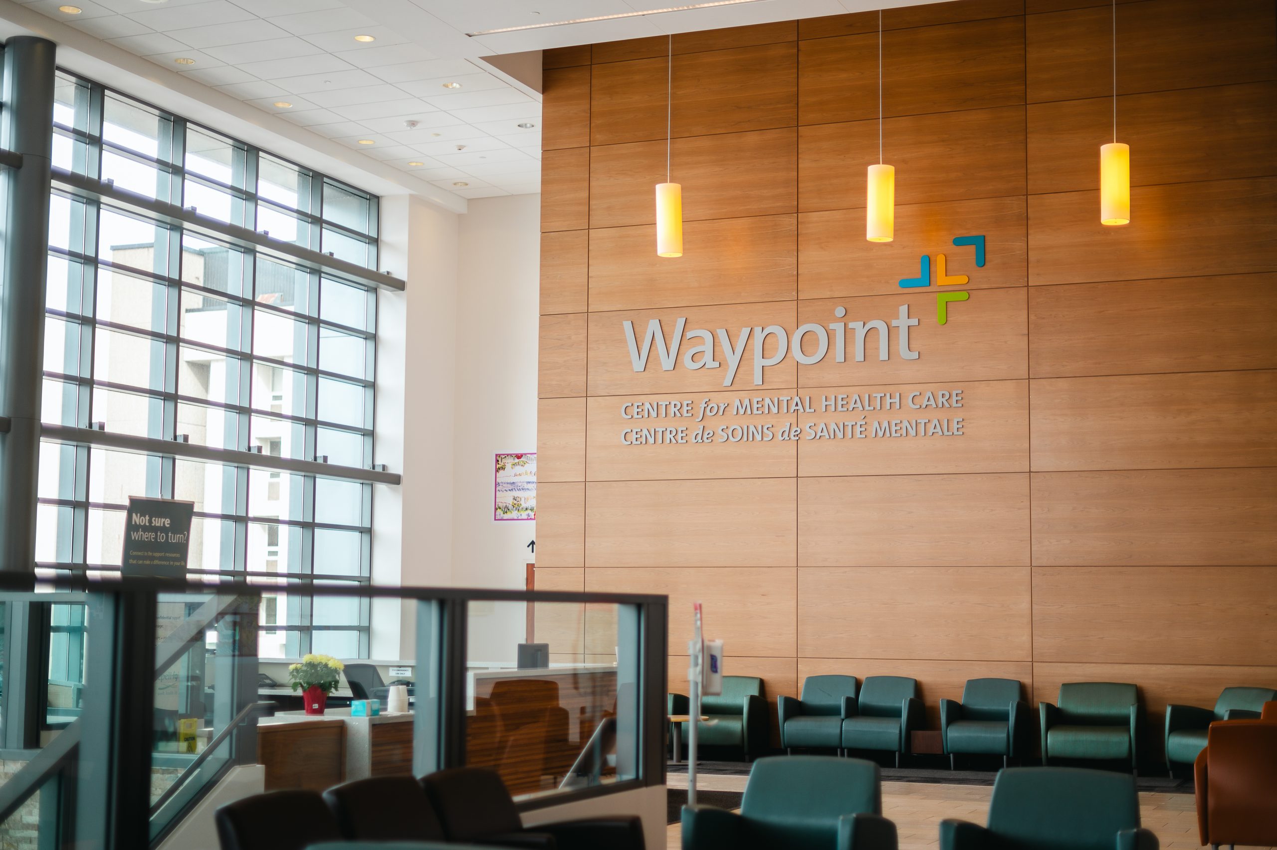 A photo of Waypoint's logo on a wood wall in the atrium lobby.