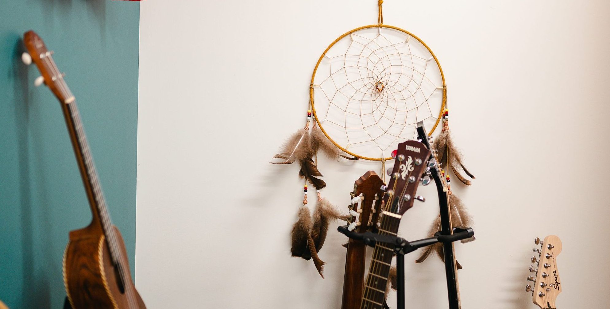 An Indigenous dream catcher hanging on the wall, surrounded by instruments.