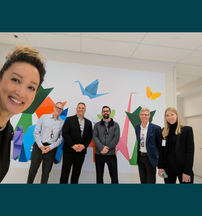 The health minister and members of the Waypoint team in front of a mural on our Provincial unit