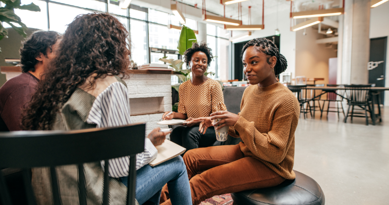 a group meeting around a table in an open lobby